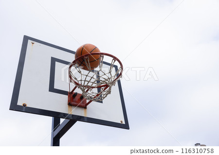 Scoring point, basketball going through hoop during outdoor game 116310758