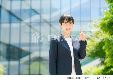 A woman in a suit standing in front of an office building 116311648