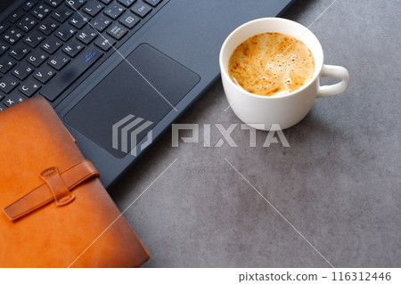 An image of someone working at a desk with a laptop and a personal organizer while drinking freshly brewed coffee An image of someone working at a desk with a laptop and a personal organizer while drinking freshly brewed coffee 116312446