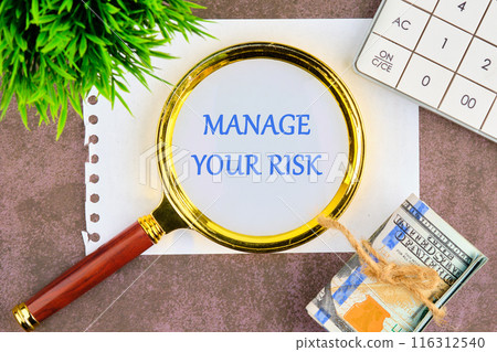 Manage your Risks symbol. Concept words Manage your Risks through a magnifying glass in a composition with American dollars, a calculator and a plant Manage your Risks symbol. Concept words Manage your Risks through a magnifying glass in a composition with American dollars, a calculator and a plant 116312540