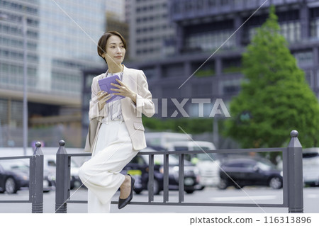 A businesswoman in an office district holding a pen tablet A businesswoman in an office district holding a pen tablet 116313896