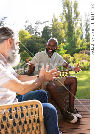 Talking and gesturing, senior friends enjoying conversation on outdoor patio Talking and gesturing, senior friends enjoying conversation on outdoor patio 116314158