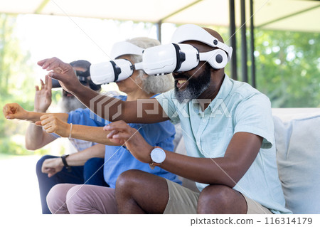At home, Diverse group of seniors using VR headsets, enjoying virtual reality experience 116314179
