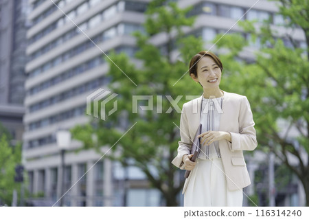 Businesswoman in an office district holding a notebook 116314240