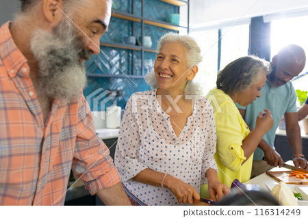 At home, Diverse group of senior friends cooking together, enjoying time in kitchen At home, Diverse group of senior friends cooking together, enjoying time in kitchen 116314249
