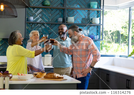 At home, Group of friends toasting drinks in modern kitchen, enjoying social gathering At home, Group of friends toasting drinks in modern kitchen, enjoying social gathering 116314276