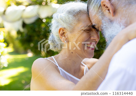 Embracing outdoors, smiling senior bride and groom at wedding 116314440