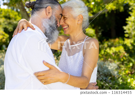 Embracing and smiling, senior bride and groom at outdoor wedding 116314455