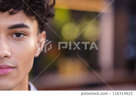Close-up of teenage boy with curly hair, half face visible, looking confident, copy space Close-up of teenage boy with curly hair, half face visible, looking confident, copy space 116314825