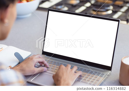 Typing on laptop, teenage boy working from home with notebook on table, copy space 116314882