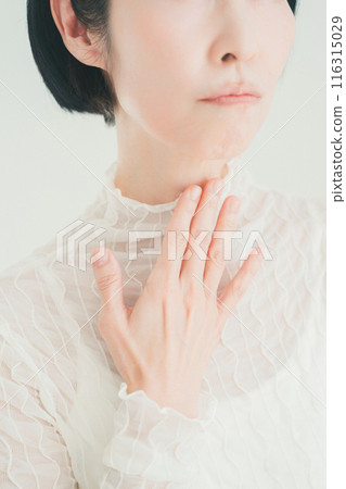 一名 50 多歲的女性摸著喉嚨 一名 50 多歲的女性摸著喉嚨 116315029