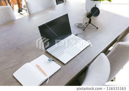 Laptop, microphone, and notebook on table, ready for home recording session 116315163