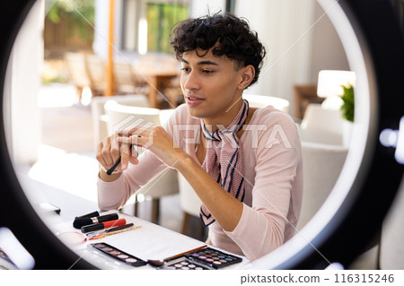 Applying makeup at home, transgender woman using cosmetics and beauty tools 116315246