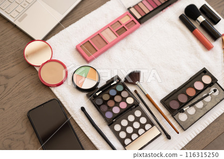 Makeup products and smartphone on table, ready for beauty routine at home Makeup products and smartphone on table, ready for beauty routine at home 116315250