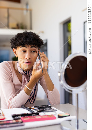 Applying makeup, transgender transgender woman using mirror and brush at home Applying makeup, transgender transgender woman using mirror and brush at home 116315294