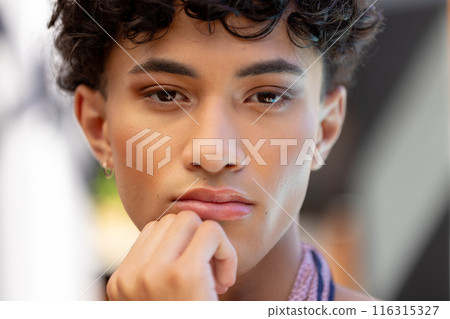 Close-up of thoughtful transgender transgender woman resting chin on hand, looking pensive 116315327