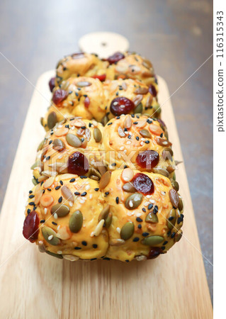 pumpkin bread or loaf of bread or bread with pumpkin seed, cranberry and sesame topping 116315343