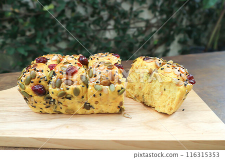 pumpkin bread or loaf of bread or bread with pumpkin seed, cranberry and sesame topping 116315353