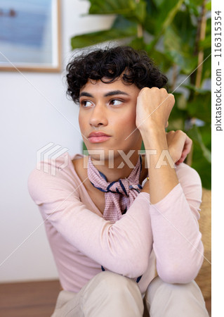 Sitting indoors, thoughtful transgender transgender woman resting chin on hand, looking away Sitting indoors, thoughtful transgender transgender woman resting chin on hand, looking away 116315354