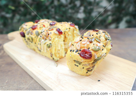 pumpkin bread or loaf of bread or bread with pumpkin seed, cranberry and sesame topping 116315355