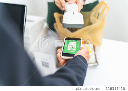 Businessman who pays QR code at convenience store / supermarket Businessman who pays QR code at convenience store / supermarket 116315410