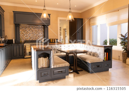 Modern kitchen with built-in dining nook and pendant lights, showcasing cozy seating, copy space Modern kitchen with built-in dining nook and pendant lights, showcasing cozy seating, copy space 116315505