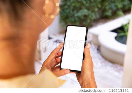 Holding smartphone with blank screen, woman standing in modern home environment, copy space Holding smartphone with blank screen, woman standing in modern home environment, copy space 116315521