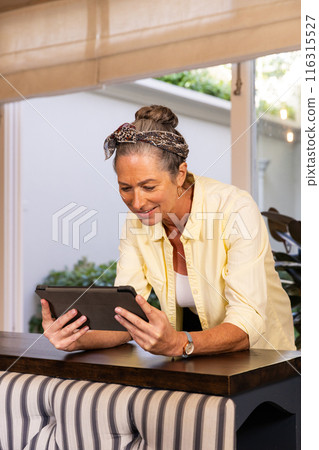 Standing at home, mature woman using tablet and smiling 116315527