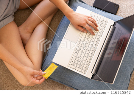 Shopping online, woman using laptop and holding credit card at home Shopping online, woman using laptop and holding credit card at home 116315842