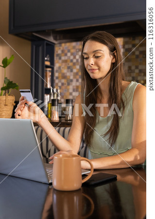 Shopping online, woman using laptop and holding credit card at home Shopping online, woman using laptop and holding credit card at home 116316056