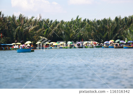 Tourists are joining the Coconut Forest Basket Boat Ride in Hoi An, vietnam. bsaket boat also called vietnamese coracle, is one of local small rounded boat for transport and fishing 116316342