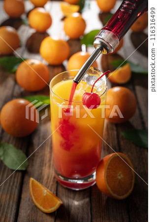 Classic tequila sunrise cocktail on an old wooden table. 116316499