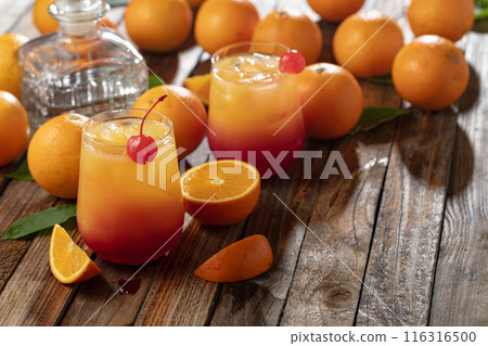 Classic tequila sunrise cocktail on an old wooden table. 116316500