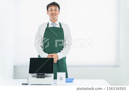 Male cashier at a convenience store, supermarket, or kioskConvenience store, cashier, apron, cashier, combination Male cashier at a convenience store, supermarket, or kioskConvenience store, cashier, apron, cashier, combination 116316503