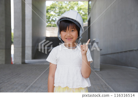 Smiling elementary school student wearing a helmet. Explanation image with pointing pose Smiling elementary school student wearing a helmet. Explanation image with pointing pose 116316514