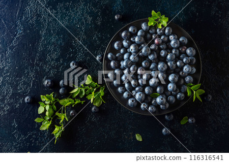 Blueberries in a black plate on a dark background. Blueberries in a black plate on a dark background. 116316541
