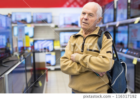 Elderly man choosing TV in showroom of electronics store 116317192