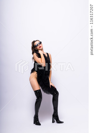 Young brunette lady in black dress posing on grey background Young brunette lady in black dress posing on grey background 116317207