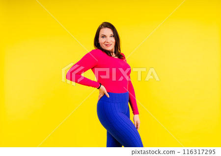 Active plus-size woman in sport top and leggings. Fitness, body positive, emotions, weight loss. Active plus-size woman in sport top and leggings. Fitness, body positive, emotions, weight loss. 116317295