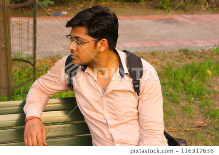 Beautiful young boy model sitting on chair in garden Beautiful young boy model sitting on chair in garden 116317636