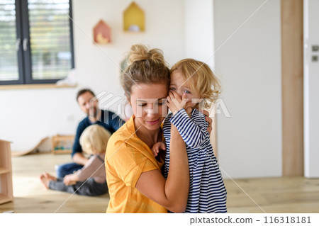Little girl crying and screaming, mother holding her in arms and soothing her. 116318181