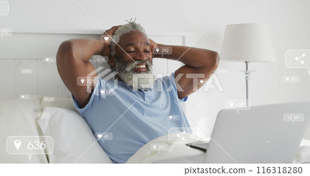 Image of social media icons on african american man having a image call on laptop in bed at home Image of social media icons on african american man having a image call on laptop in bed at home 116318280