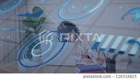Image of infographic interface over biracial woman writing notes and using laptop on desk 116318825