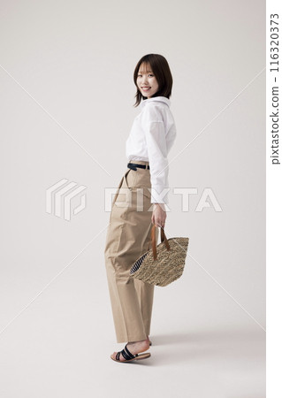 Korean Woman Wearing Beige Pants and Holding Bags Korean Woman Wearing Beige Pants and Holding Bags 116320373