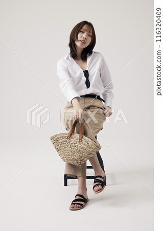 A Korean Woman Poses in a Chair With a Bag A Korean Woman Poses in a Chair With a Bag 116320409