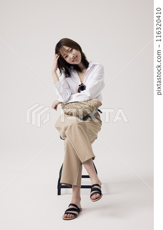 A Korean Woman Poses in a Chair Holding a Bag A Korean Woman Poses in a Chair Holding a Bag 116320410