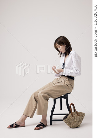 Korean Woman Sitting in Chair in Old Money Style Korean Woman Sitting in Chair in Old Money Style 116320416