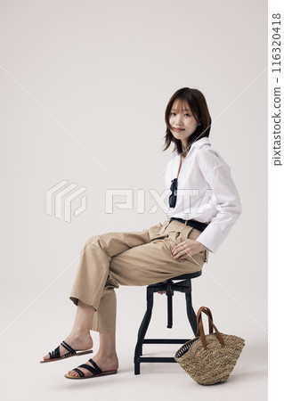 Korean Woman Sitting in Chair in Old Money Style 116320418