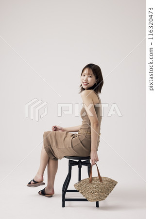 Korean Woman Poses With Bags Sitting in Chair Korean Woman Poses With Bags Sitting in Chair 116320473