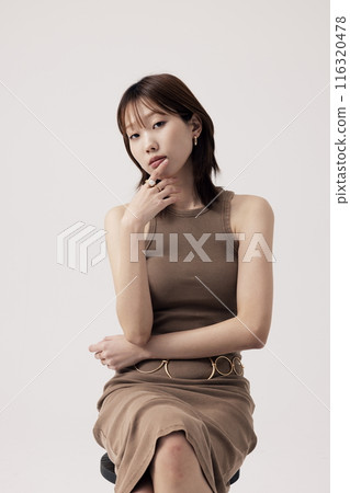 Korean Woman Poses in a Chair in Beige Knit Dress 116320478